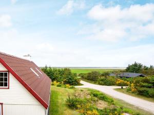 法贾德嘉德7 person holiday home in Ulfborg的一座有红色屋顶和土路的房子
