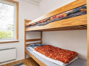 SindrupThree-Bedroom Holiday home in Hurup Thy 8的一间卧室配有双层床和窗户。