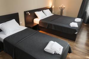 桑丹斯基帕塔利亚家庭酒店的酒店客房,配有两张带毛巾的床