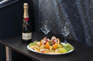 桑丹斯基帕塔利亚家庭酒店的一瓶葡萄酒和酒杯,配上一盘食物