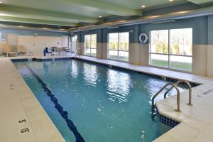 布赖顿Holiday Inn Express & Suites - Brighton South - US 23, an IHG Hotel的蓝色海水大型游泳池,窗户