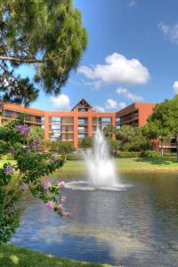 奥兰多Rosen Inn Lake Buena Vista的池塘中央的喷泉,在建筑物前