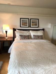 维多利亚one bedroom suite near Hillside mall的一间卧室配有一张大床和一张带台灯的桌子