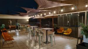 圣地亚哥Hostel Boutique Merced 88的一间带桌椅和遮阳伞的餐厅