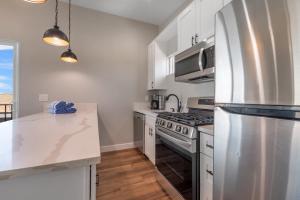 圣地亚哥Mission Bay Vista的厨房配有白色橱柜和不锈钢冰箱