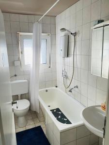 多特蒙德Bei Daniel am Dortmunder Flughafen的带浴缸、卫生间和盥洗盆的浴室