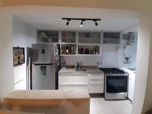 里约热内卢Apartamento Padrão em condominio completo no Recreio的厨房配有不锈钢用具和白色橱柜
