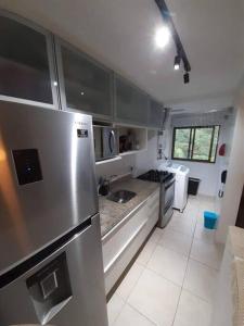 里约热内卢Apartamento Padrão em condominio completo no Recreio的厨房配有不锈钢冰箱和电器