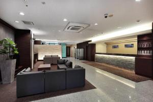大阪Via Inn Shin Osaka的大楼内一个带沙发和椅子的大堂