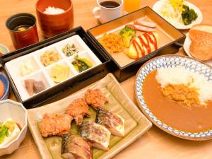大阪Via Inn Shin Osaka West的一张桌子,上面放着各种食物的托盘