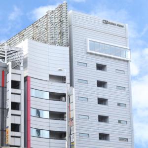 大阪Via Inn Umeda的一座高大的白色建筑,上面有标志
