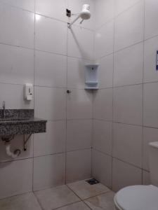 大坎普Pousada Recanto Alaketu Hospedagens的白色瓷砖浴室设有卫生间和淋浴。