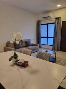 莎阿南Modern 4BR Double Storey @ Setia Alam的客厅配有沙发和鲜花桌