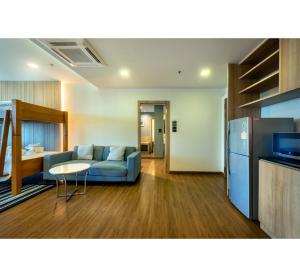罗勇PLAAI Prime Hotel Rayong SHA Extra Plus的客厅配有沙发和桌子