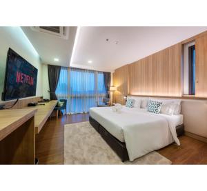罗勇PLAAI Prime Hotel Rayong SHA Extra Plus的酒店客房设有一张大床和一台电视。