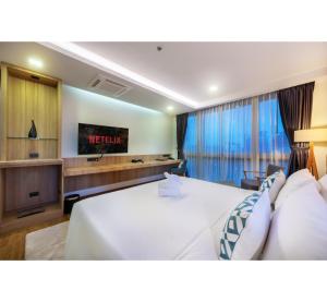 罗勇PLAAI Prime Hotel Rayong SHA Extra Plus的酒店客房设有一张大床和一台电视机。
