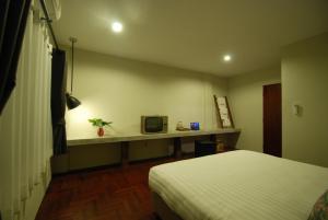 清迈清迈白平舒适旅馆的客房设有一张床、一张书桌和电视