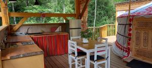 CarbucciaYourte indépendante en pleine nature, proche d'Ajaccio的一间厨房和一个带帐篷的甲板上的一张桌子