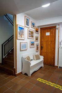 卡塞雷斯Hostal Plaza de Italia的客厅配有白色沙发,墙上挂有图片