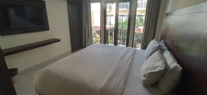 库塔苏里斯精品酒店的卧室配有白色的床和阳台