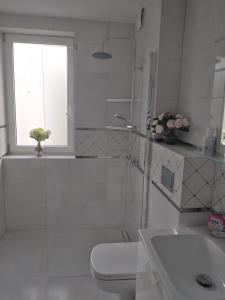 奥尔什丁Pokoje gościnne Słupy Olsztyn - parking的白色的浴室设有卫生间和窗户。