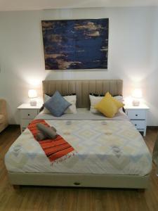 史里肯邦安Apple Home 2 at Menara Simfoni, King Size Bed, Cheras, Nexflix, Wifi, Parking的一间卧室配有一张带两张桌子和两盏灯的床。