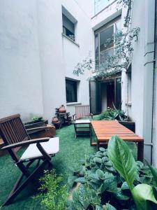 索尔索纳Hostal Crisami的庭院设有木桌、椅子和植物