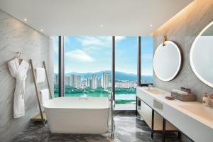 泉州泉州滨江皇冠假日酒店的带浴缸的浴室和大窗户