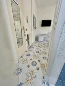 伊斯基亚La Bicocca di Annavì的走廊设有瓷砖地板和客房