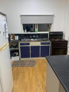 MarloRalf's Coastal Shack的厨房配有蓝色橱柜和黑色台面