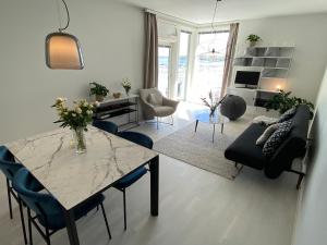 赫尔辛基Luxury 1-bedroom apartment with sauna and sea view的一间带桌椅的客厅和一间客厅。