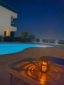 珊瑚湾3 Bedroom Seaview Villa direct in Coral Bay with Pool的游泳池旁的一张桌子上放着蜡烛