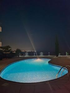 珊瑚湾3 Bedroom Seaview Villa direct in Coral Bay with Pool的夜间大型蓝色游泳池,有彩虹