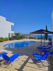 珊瑚湾3 Bedroom Seaview Villa direct in Coral Bay with Pool的一组椅子和一把遮阳伞,位于游泳池旁