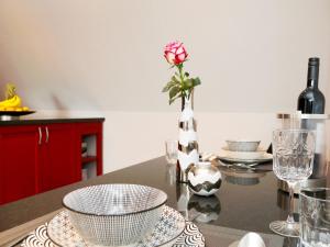 奥尔珀Ferienwohnungen Schimsheimer Rhode的厨房里设有一张桌子,上面有玫瑰花瓶