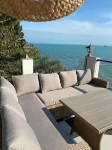 格里戈莱蒂Claude Monet Seaside Hotel的一个带沙发和桌子的庭院和大海