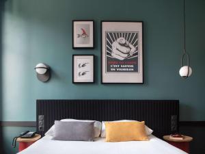 第戎宜必思中央酒店的卧室配有一张墙上三幅照片的床