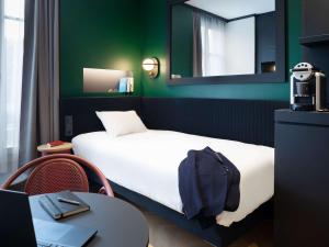 第戎宜必思中央酒店的客房设有床、桌子和镜子