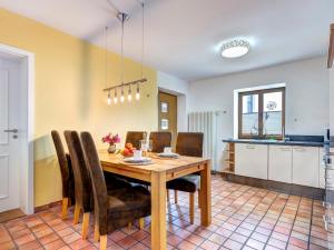 奥斯特西巴德钦诺维茨FeWo Tusculum的厨房以及带木桌和椅子的用餐室。