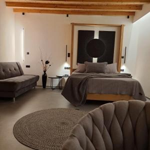 埃尔莫波利斯Nisaki Hotel & Elite Suites的一间卧室配有一张大床和一张沙发