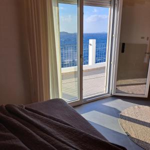 埃尔莫波利斯Nisaki Hotel & Elite Suites的卧室设有海景阳台。