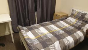 阿什顿下安林恩2 bedroom apartment in Greater Manchester的一间卧室配有一张带黑白毯子的床
