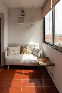 布拉干萨Bragança Apartments的客厅配有白色沙发和窗户