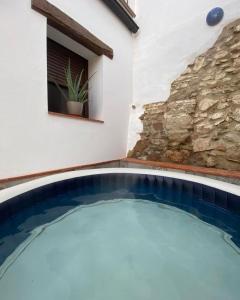 Cumbres de San BartoloméTío Genaro的一座石墙房子前面的游泳池