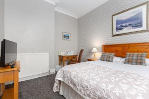 巴罗弗内斯欧姆斯吉尔宾馆的一间卧室配有一张床和一台平面电视
