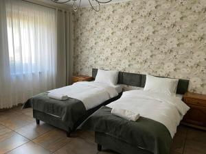 鲁达希隆斯卡Apartamenty Jaskinia Solna的一间卧室设有两张床和鲜花墙