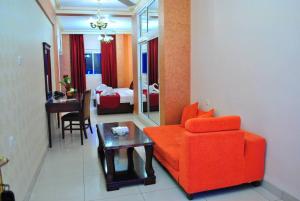 亚喀巴亚喀巴套房酒店的客厅配有红色的沙发和桌子