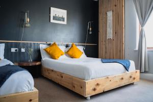 BigStyle Atlantic Lodge的一间卧室配有两张带黄色枕头的床