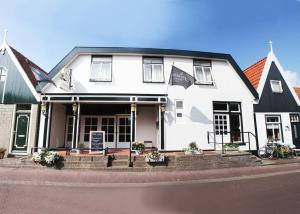 登霍伦Hotel-Restaurant Loodsmans Welvaren的黑色屋顶的白色房子