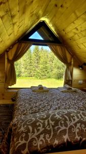 ŠljivovicaBrvnara Miris Bora的帐篷内的一张大床,设有窗户